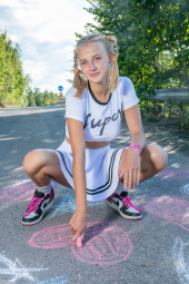 Cute young blonde is outdoor wearing white t-shirt and white skirt