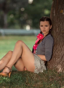 Young beauty in red bikini undresses on the beach